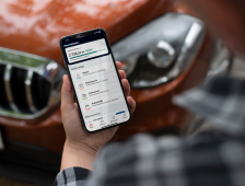 mężczyzna korzystający z smartphone na tle samochodu